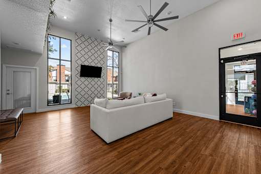 a living room with a white couch and a ceiling fan