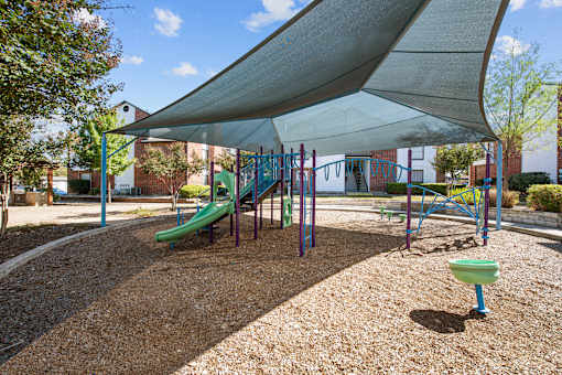 a playground with a swing set and a canopy