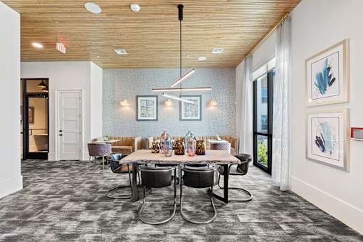 A dining room with a table set for six people.