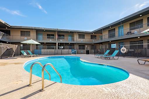 A swimming pool in a sunny outdoor pool area.