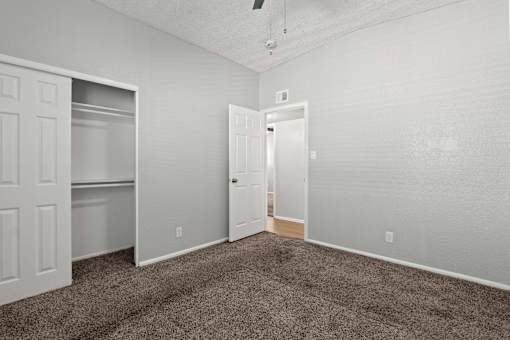 A room with a carpeted floor and two doors.