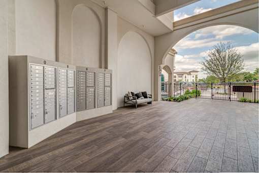 A room with a wooden floor and a wall with a row of lockers.