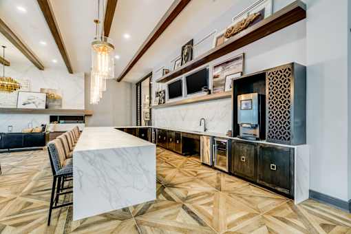 A kitchen with a marble table and wooden floors.