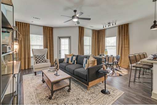 A living room with a black sofa and a wooden coffee table.