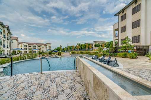 A swimming pool surrounded by a tiled floor and a concrete wall.