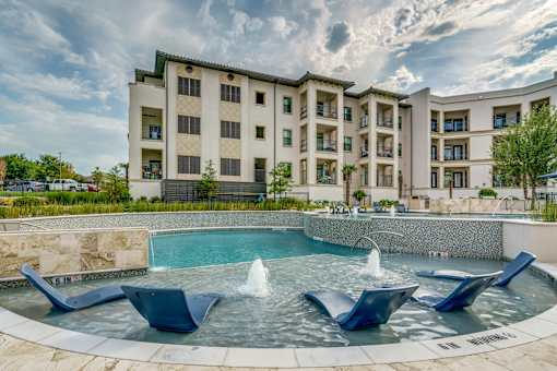 A large building with a pool in front of it.