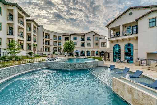 A large swimming pool in front of apartment buildings.