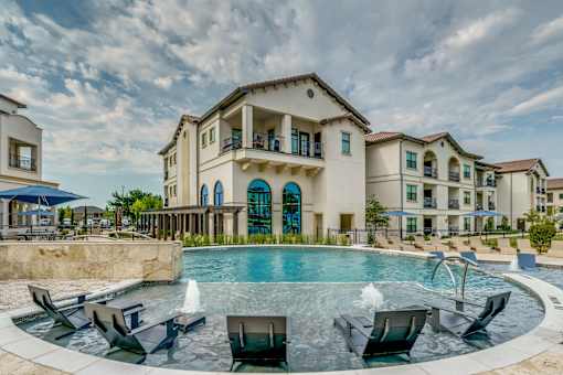 A large building with a pool in front of it.