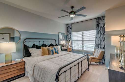 A bedroom with a large bed and a ceiling fan.