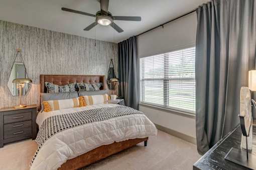 A bedroom with a large bed and a ceiling fan.