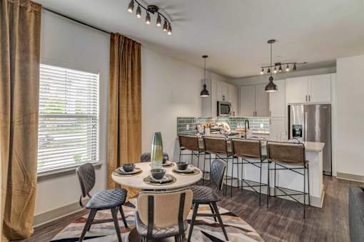 A modern kitchen with a dining table set for four.