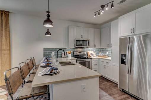 A modern kitchen with a long table and chairs.
