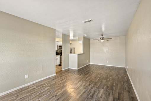 A room with wooden flooring and a ceiling fan.