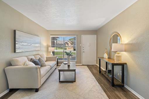 A living room with a white couch and a coffee table.