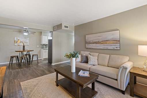 A living room with a couch, coffee table, and a painting on the wall.