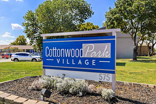 A sign for Cottonwood Park Village with the number 575 on it.