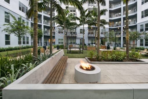 a fire pit in the courtyard of an apartment building