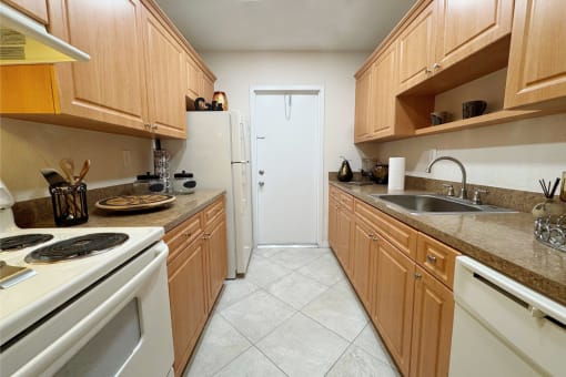 a kitchen with white appliances and wooden cabinets