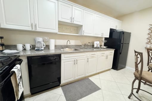 a kitchen with black appliances and white cabinets