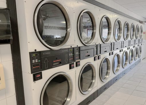 a row of industrial washing machines in a laundromat