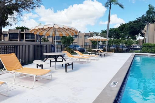 a swimming pool with chairs and umbrellas at a hotel