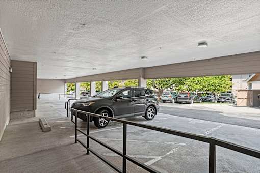 A car is parked in a covered parking lot.