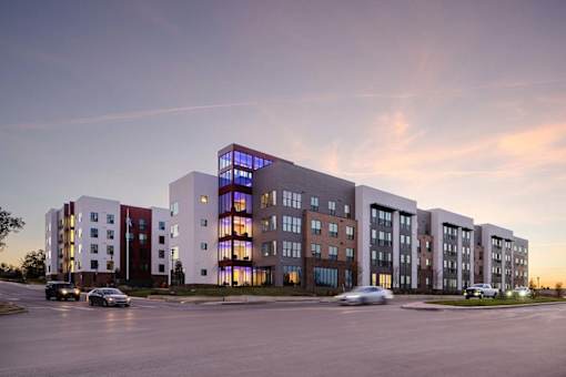A modern building with a parking lot in front of it.