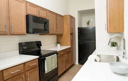 A kitchen with wooden cabinets and black appliances.