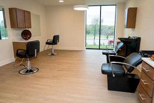 A living room with black chairs and a wooden cabinet.
