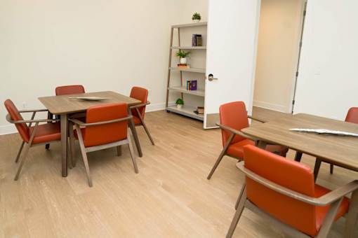 A room with a table and chairs and a bookshelf.