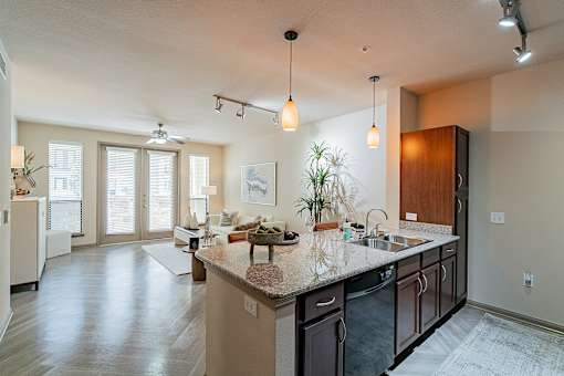 A kitchen with a large island and pendant lights.