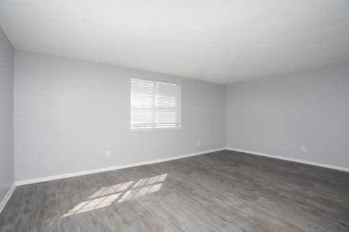 an empty room with a wooden floor and a window