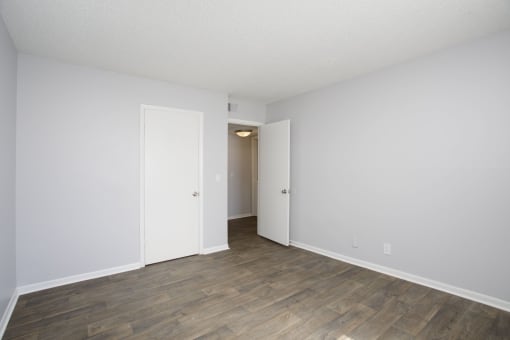 a bedroom in a 555 waverly unit with a hardwood floor and white walls