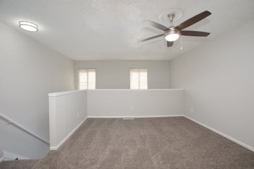 a large empty room with a ceiling fan