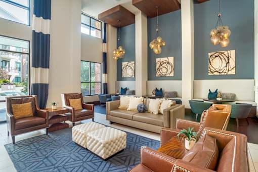A living room with brown leather chairs and a white ottoman.