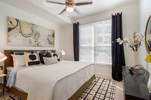 A bedroom with a large bed and a ceiling fan.