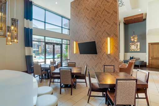 A modern dining room with a wooden patterned wall and a large table with chairs.