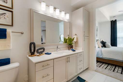 A bathroom with a white vanity and a large mirror.