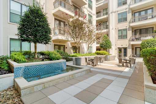 A large white building with a pool in the courtyard.