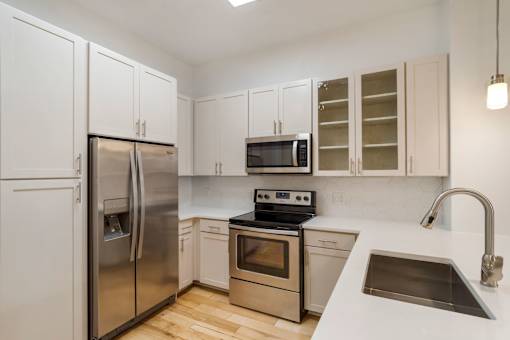 A kitchen with white cabinets and stainless steel appliances.