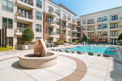 A large stone fountain is in the middle of a courtyard.
