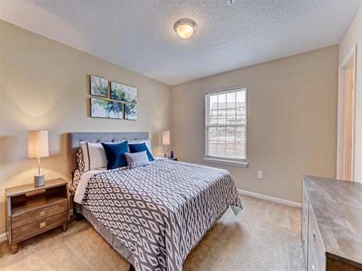 A bedroom with a large bed and a window.
