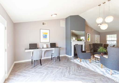 A room with a grey carpet and a grey sofa.