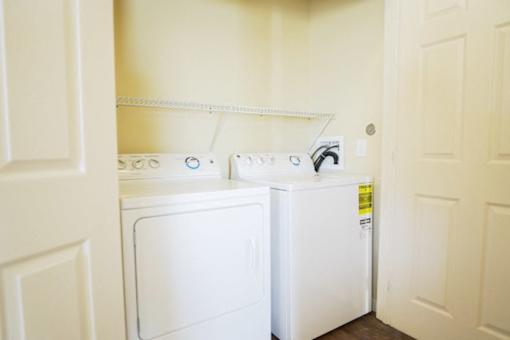 A white washing machine and dryer in a small laundry room.
