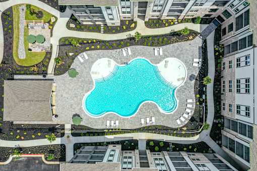 A swimming pool in the middle of a courtyard surrounded by buildings.
