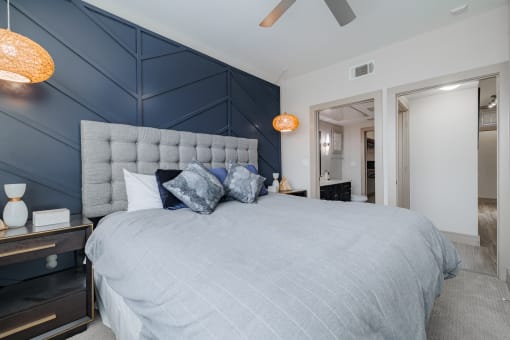 a bedroom with a large bed and a blue accent wall