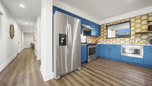 a kitchen with blue cabinets and stainless steel appliances