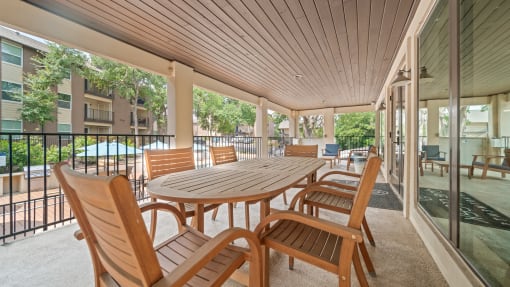 a patio with a wooden table and chairs