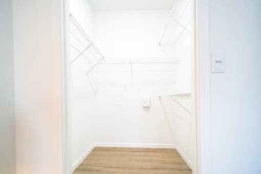 a white room with a wood floor and a white door