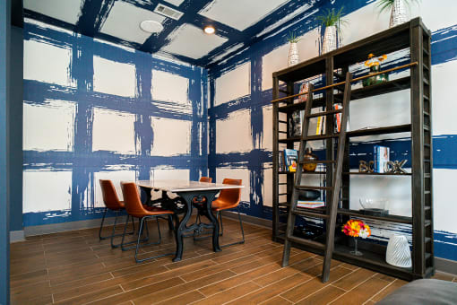 a dining room with blue walls and a table and chairs
